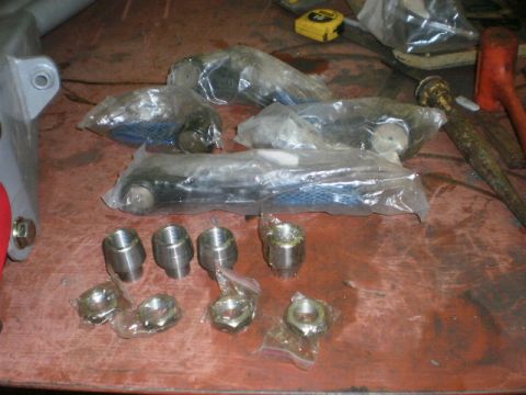 1995 Ford Bronco - New suspension parts, possibly for a Ford Bronco, are organized on a workbench with tools nearby.