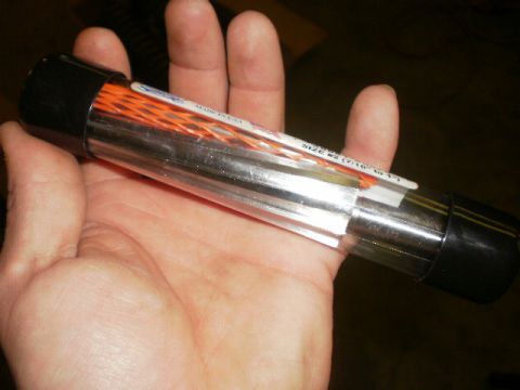 1995 Ford Bronco - A clear plastic tube containing orange wire loom is held in a person's hand.