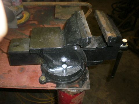 1995 Ford Bronco - Bench vise on a workbench, with tools and equipment in the background.