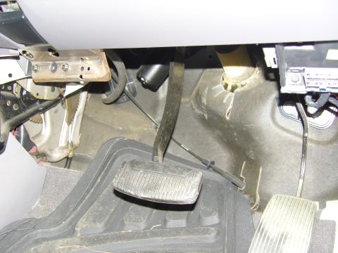 2007 Ford Mustang - The driver's side footwell of a vehicle, showing the brake pedal and part of the gas pedal assembly.
