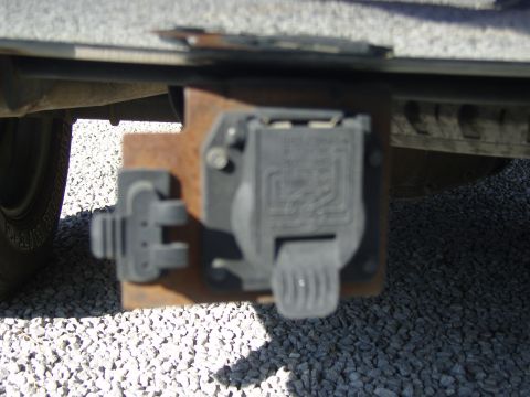 2007 Ford Mustang - Close-up of a trailer hitch connector, showing the wiring harness receptacle and mounting bracket.