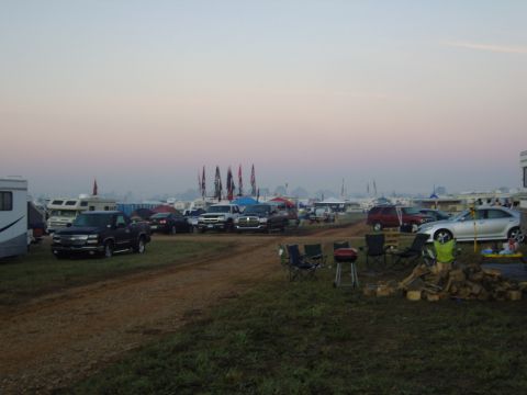 2007 Ford Mustang - A campground scene with multiple vehicles, including RVs and trucks, parked under a hazy sky.