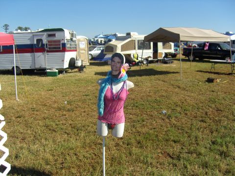 2007 Ford Mustang - A mannequin with a cutout face and clothing is displayed in a field with camping equipment.