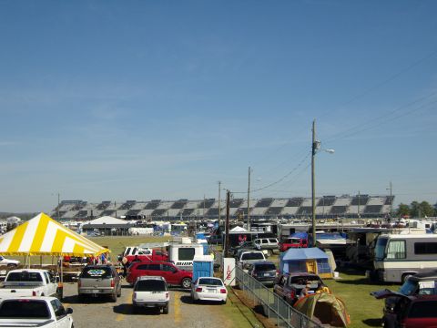 2007 Ford Mustang - A busy parking area at a racetrack, with tents and RVs set up near the grandstands.