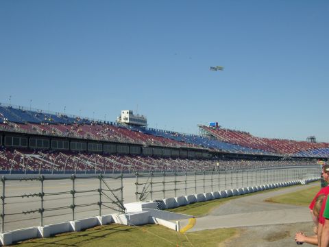 2007 Ford Mustang - A wide view of a racetrack's grandstands under a bright blue sky, with a banner visible in the distance.