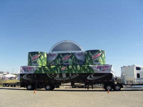 2007 Ford Mustang - A large trailer displays a stage and Mountain Dew 250 advertising, connected to a semi-truck.