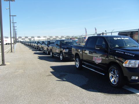 2007 Ford Mustang - Multiple black Ram 1500 trucks are parked in a line, branded as official vehicles for Talladega.