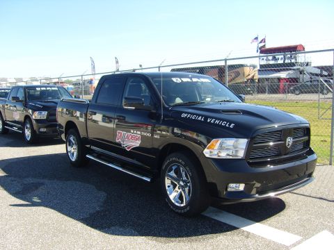 2007 Ford Mustang - Official vehicles for an event, these black Ram 1500 pickup trucks are lined up on a sunny day.