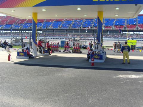 2007 Ford Mustang - A Sunoco gas station is set up at a racetrack, with fuel pumps and crew members visible.