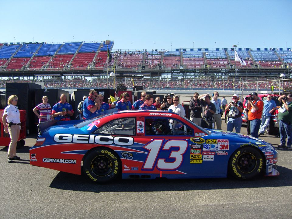 Side view of a blue and red race car with number 13 and GEICO branding