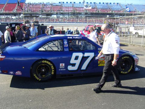 2007 Ford Mustang - A blue NASCAR race car numbered 97 is on the track with spectators in the background.