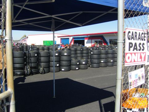 2007 Ford Mustang - A large quantity of tires are stacked and organized, with a sign indicating restricted access to the garage area.
