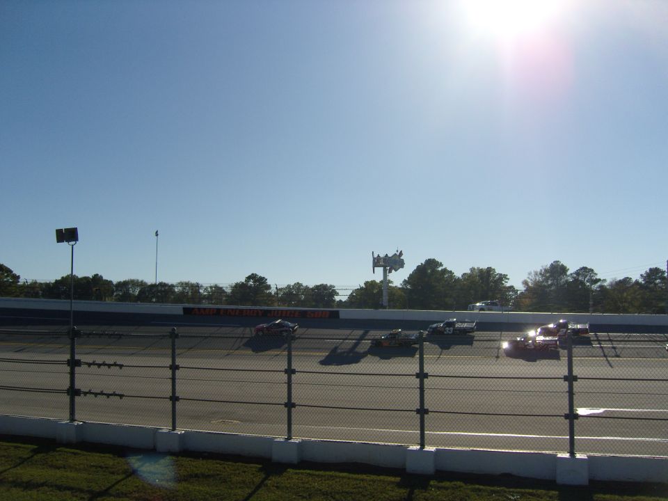 Race cars on a track under a bright sun