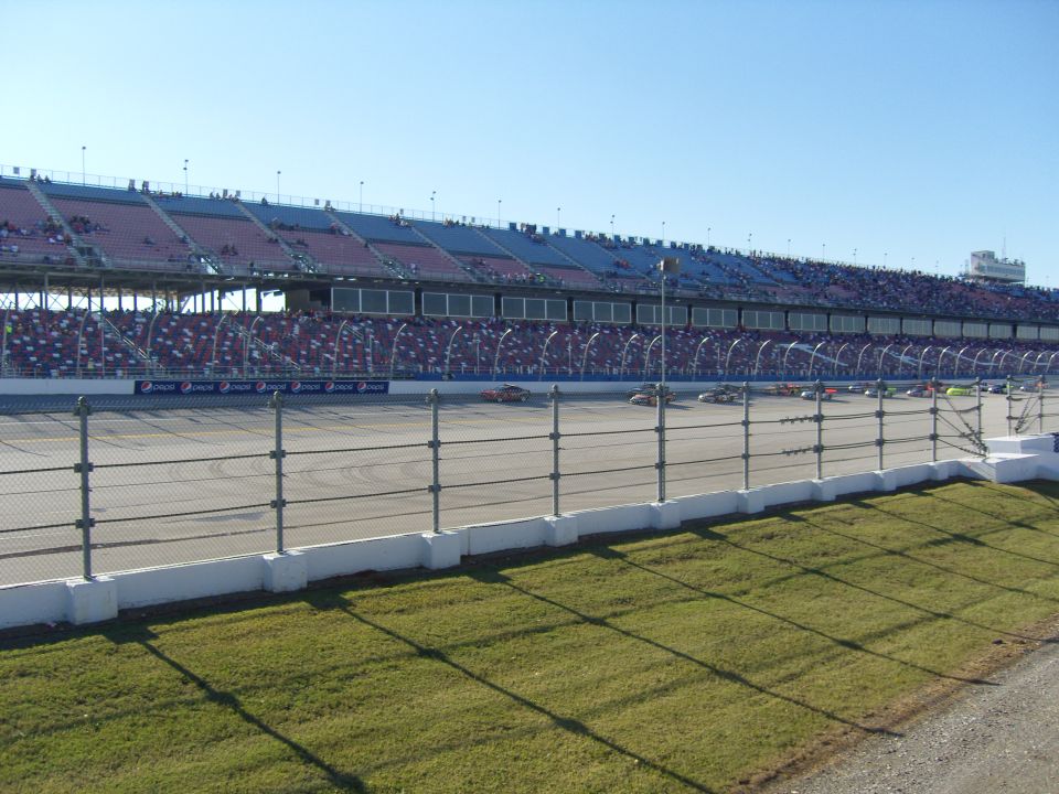 Race cars on a track with grandstands in the background
