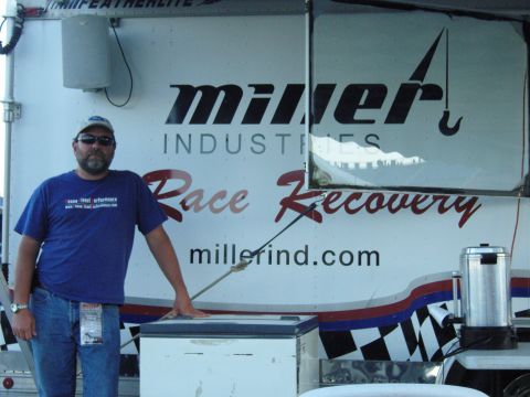 2007 Ford Mustang - Man stands in front of a trailer for Miller Industries Race Recovery, which specializes in towing and recovery services.