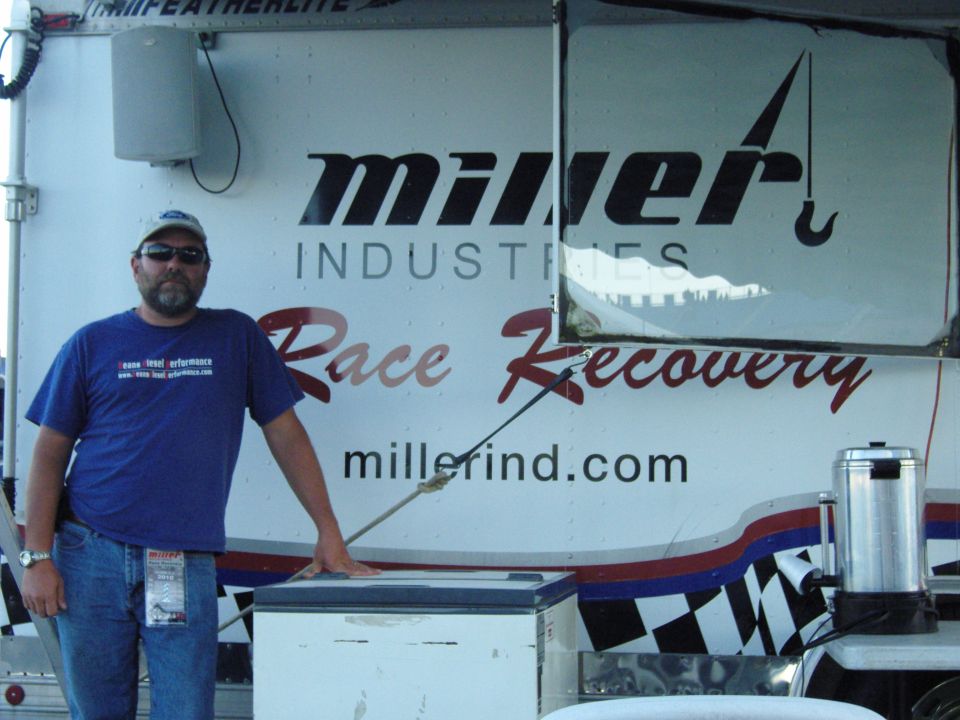 Man in front of Miller Industries Race Recovery trailer