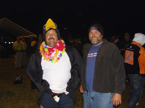 2007 Ford Mustang - Two men pose for a photo at an outdoor event at night, one wearing a penguin costume.