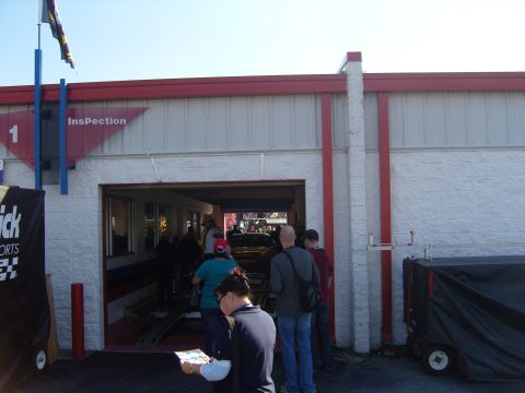 2007 Ford Mustang - People are gathered near a building entrance labeled "Inspection" with a flag flying above.