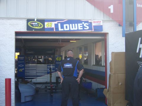 2007 Ford Mustang - A NASCAR pit crew garage is shown with a man in a Lowe's uniform standing in the doorway.