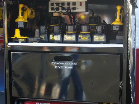 2007 Ford Mustang - A charging station for DeWalt power tools is organized with multiple batteries and chargers, alongside a drawer for riveters.