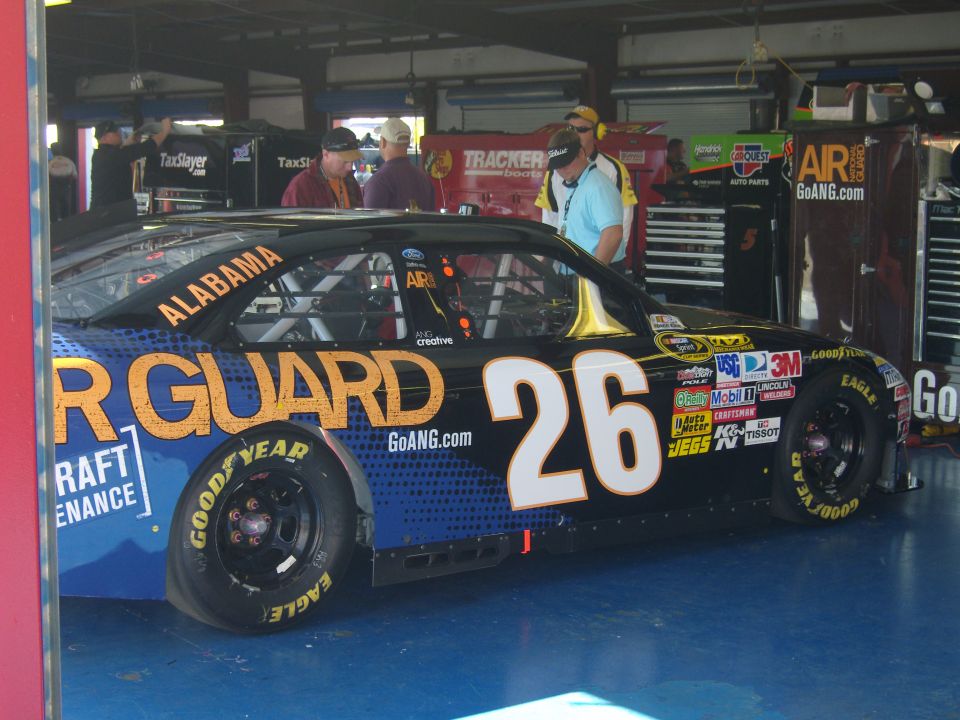 Race car #26 with "AIR GUARD" and "ALABAMA" text, parked in a garage