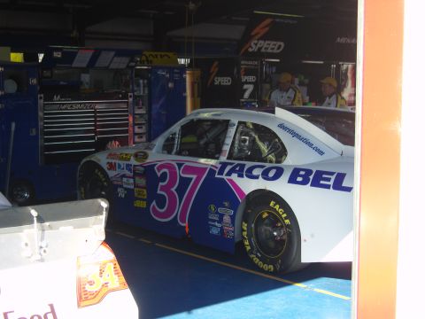 2007 Ford Mustang - A race car with "Taco Bell" branding and the number 37 is seen in a garage pit stall.
