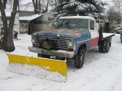 1972 Ford F-250 - This Ford pickup truck is equipped with a snow plow and parked in a snowy outdoor setting.