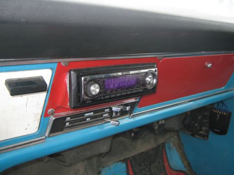 1972 Ford F-250 - Close-up of the dashboard showing an aftermarket stereo and climate control sliders.