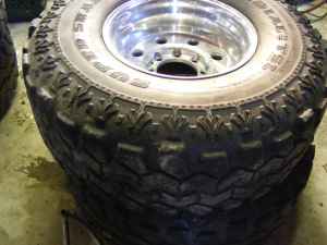 1984 Ford Bronco - A SuperMotors.net branded image shows a close-up of a tire and wheel assembly, likely for an off-road vehicle.