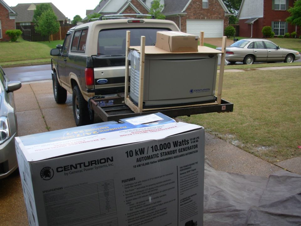 Standby generator crated on a truck bed rack with shipping box