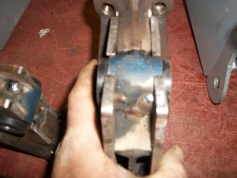 1995 Ford Bronco - A person is holding a metal mechanical component, likely a vehicle part, for inspection.
