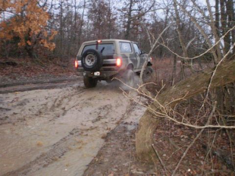 1995 Ford Bronco - This 1995 Ford Bronco navigates a muddy trail in a wooded area.