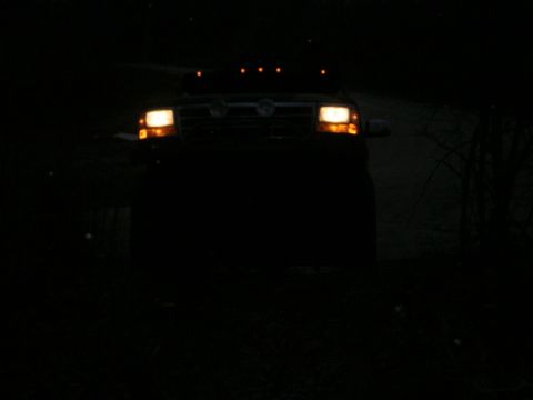 1995 Ford Bronco - A truck is seen from the front at night with its headlights illuminated.