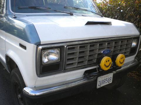 1989 Ford Bronco - This van features a distinctive grille and dual yellow fog lights with smiley faces.