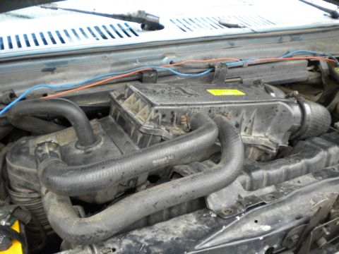 1989 Ford Bronco - Close-up view of a vehicle's engine bay, showing various hoses and the air intake system.