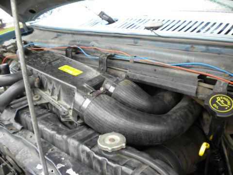 1989 Ford Bronco - Close-up view of the engine bay, focusing on the air intake system and various hoses.