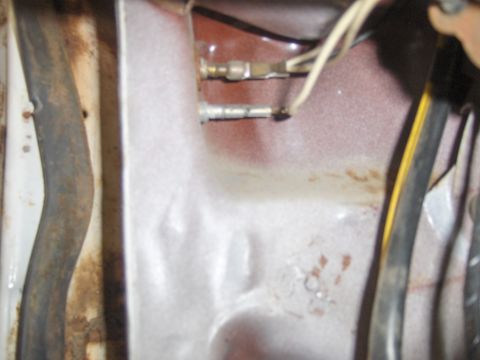 1972 Chevrolet Camaro - This image shows a close-up view of electrical wiring and metal parts within a vehicle's structure.