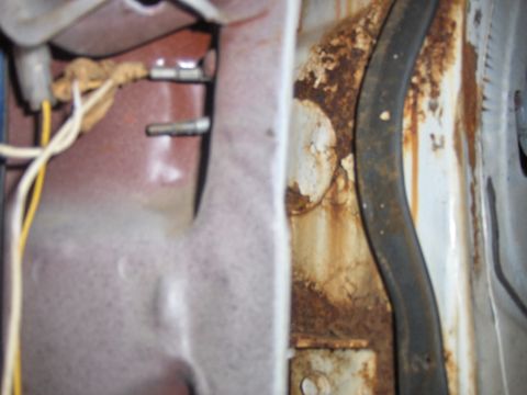 1972 Chevrolet Camaro - A heavily rusted car door jamb shows exposed wiring and a black rubber seal, indicating significant wear and tear.