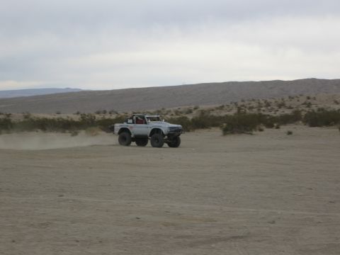 1986 Ford Bronco - 1986 Ford Bronco navigating a dusty desert terrain.