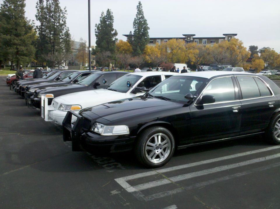 Black 2004 Ford Crown Victoria police car with a push bumper, parked in a lot