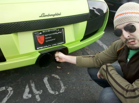 2004 Ford Crown Victoria - Man puts fist into the exhaust pipe of a green Lamborghini.