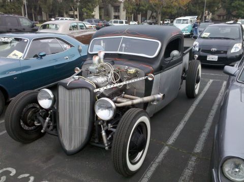 2004 Ford Crown Victoria - A custom hot rod pickup truck with a supercharger and flame details is parked in a lot with other vehicles.