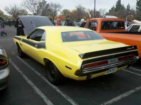 2004 Ford Crown Victoria - This yellow 1970 Dodge Challenger features a distinctive black stripe and rear spoiler, seen parked at an outdoor event.