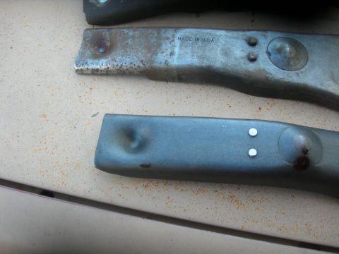 1984 Ford Bronco - Close-up of two metal components, one showing stamped text and the other with a dent.