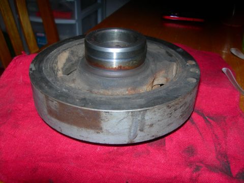1984 Ford Bronco - A worn crankshaft pulley sits on a red cloth, showing signs of age and use.
