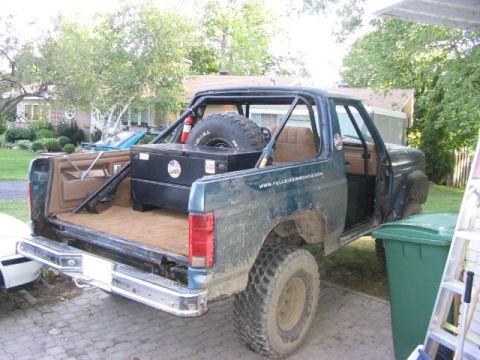 1986 Ford Bronco - This modified Ford Bronco features a roll cage and a spare tire mounted in the cargo area.