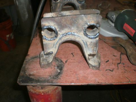 1995 Ford Bronco - A close-up view of a welded metal bracket, likely a vehicle part, on a workbench.