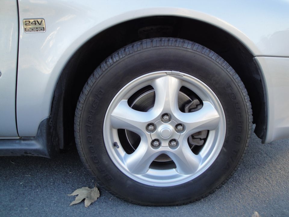 Silver 5-spoke alloy wheel with BFGoodrich Touring T/A tire and 24V DOHC badge