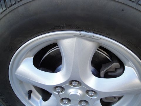 2003 Ford Taurus - A close-up view of a vehicle's wheel, tire, and brake assembly.