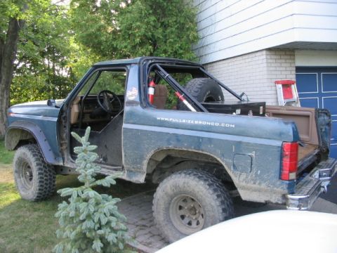 1986 Ford Bronco - This SUV, likely from the early 1980s, features a roll cage and a spare tire mounted in the cargo area.